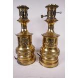 A pair of brass table lamps with raised decoration of cherubs and winged seahorses, 14" high