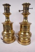 A pair of brass table lamps with raised decoration of cherubs and winged seahorses, 14" high