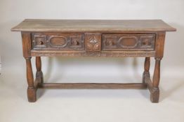 A C19th oak sideboard, with plank top and two drawers, carved sides and front, raised on turned