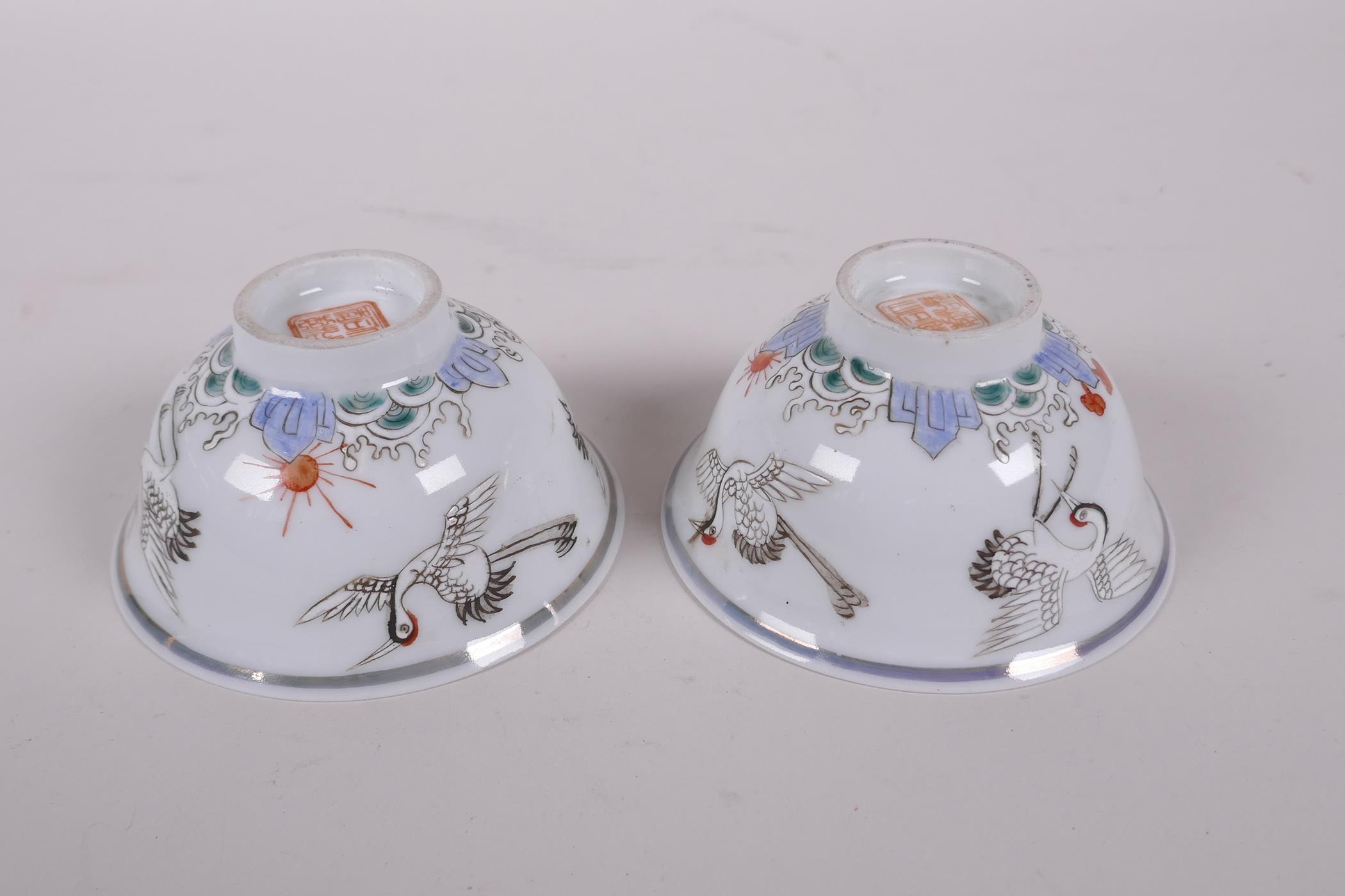 A pair of early C20th Chinese polychrome porcelain tea bowls decorated with cranes, seal mark to - Image 4 of 6