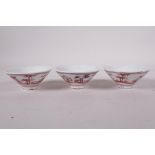 Three Chinese Ming style porcelain export tea bowls with red and white decoration of travellers,