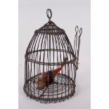 A domed wire bird cage with woven banding, housing a model bird with metal head and feet, 11" high