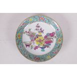 A famille rose porcelain cabinet dish decorated with objects of virtue within a floral border,