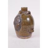 A Chinese Song style olive glazed pottery wine pourer with raised fruiting vine decoration, 5" high
