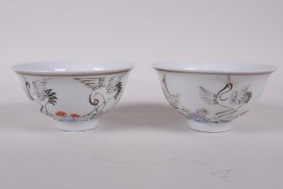 A pair of early C20th Chinese polychrome porcelain tea bowls decorated with cranes, seal mark to