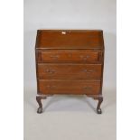 An Edwardian fall front bureau with three drawers, the interior fitted with pigeon holes, raised