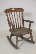 A child's elm Windsor stick back rocking chair, 24" high, 11" wide