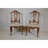 A pair of C18th French walnut pierced splat back side chairs with finely carved decoration, raised