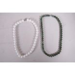 A green hardstone bead necklace and a white ceramic bead necklace, longest 19"