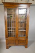 An oak bookcase with leaded glass doors and cupboard to the lower section, 42" x 15", 73" high