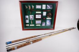 A cased display of fishing ephemera and two vintage 7' fly fishing rods