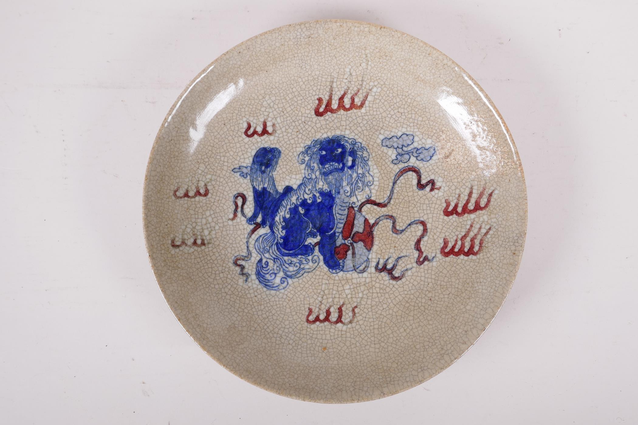 A Chinese crackle ware dish with blue, white and red temple lion decoration, 10" diameter