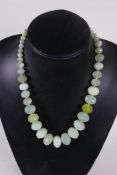 A graduated string of faceted green jade beads, 20" long