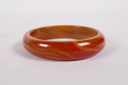 An amber coloured agate bangle, 3" diameter