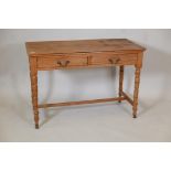 A satin walnut two drawer writing table on ring turned supports and plain stretchers, 29" high,
