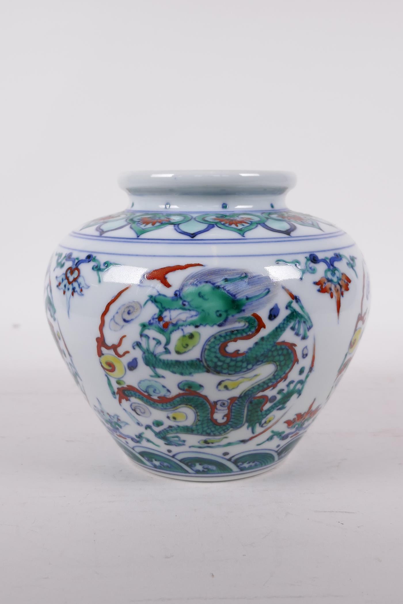 A Doucai porcelain jar decorated with five toed dragons chasing the flaming pearl, six character
