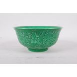 An apple green glazed porcelain rice bowl with raised dragon decoration, six character mark to base,