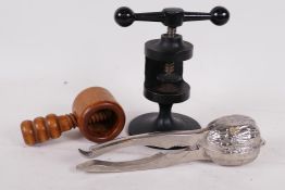 A cast iron nut cracker made in the form of a fly press, 6" high closed, together with two other nut