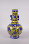 A Ming style yellow ground porcelain vase with two elephant mask handles, with blue and white