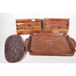 Four Indian carved hardwood items, two stationery racks and two trays, largest 21" x 12"