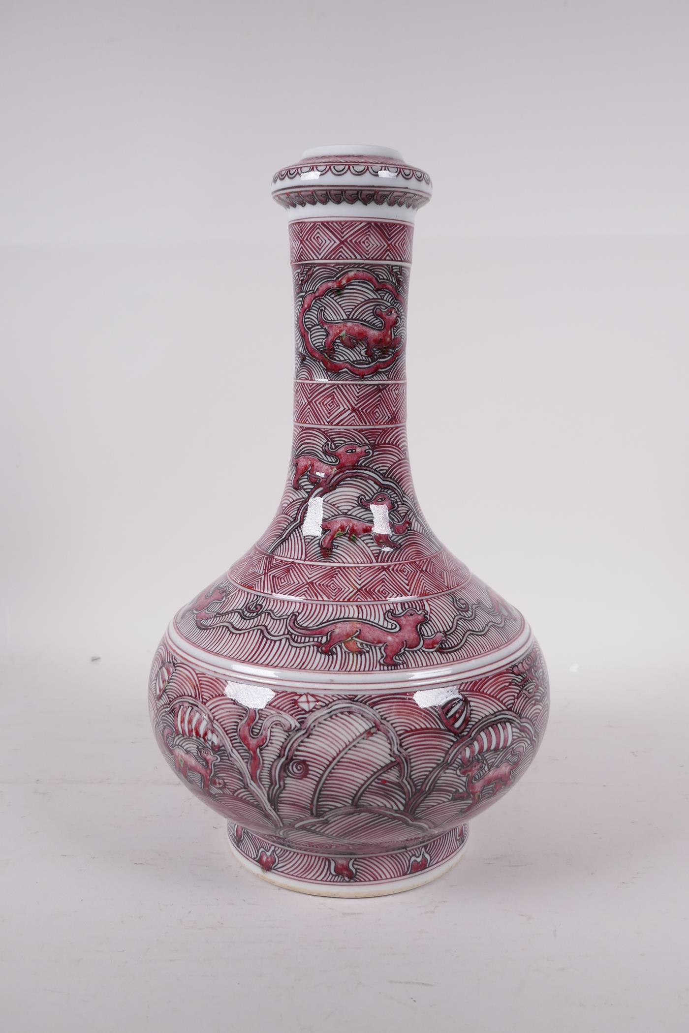 A Chinese red and white bottle vase decorated with mythical creatures, six character mark to base,