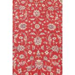 A French Persian style red ground wool carpet with scrolling floral decoration and ivory borders,