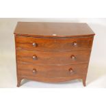 A George III mahogany bow fronted chest of three long drawers, with turned wood handles, raised on