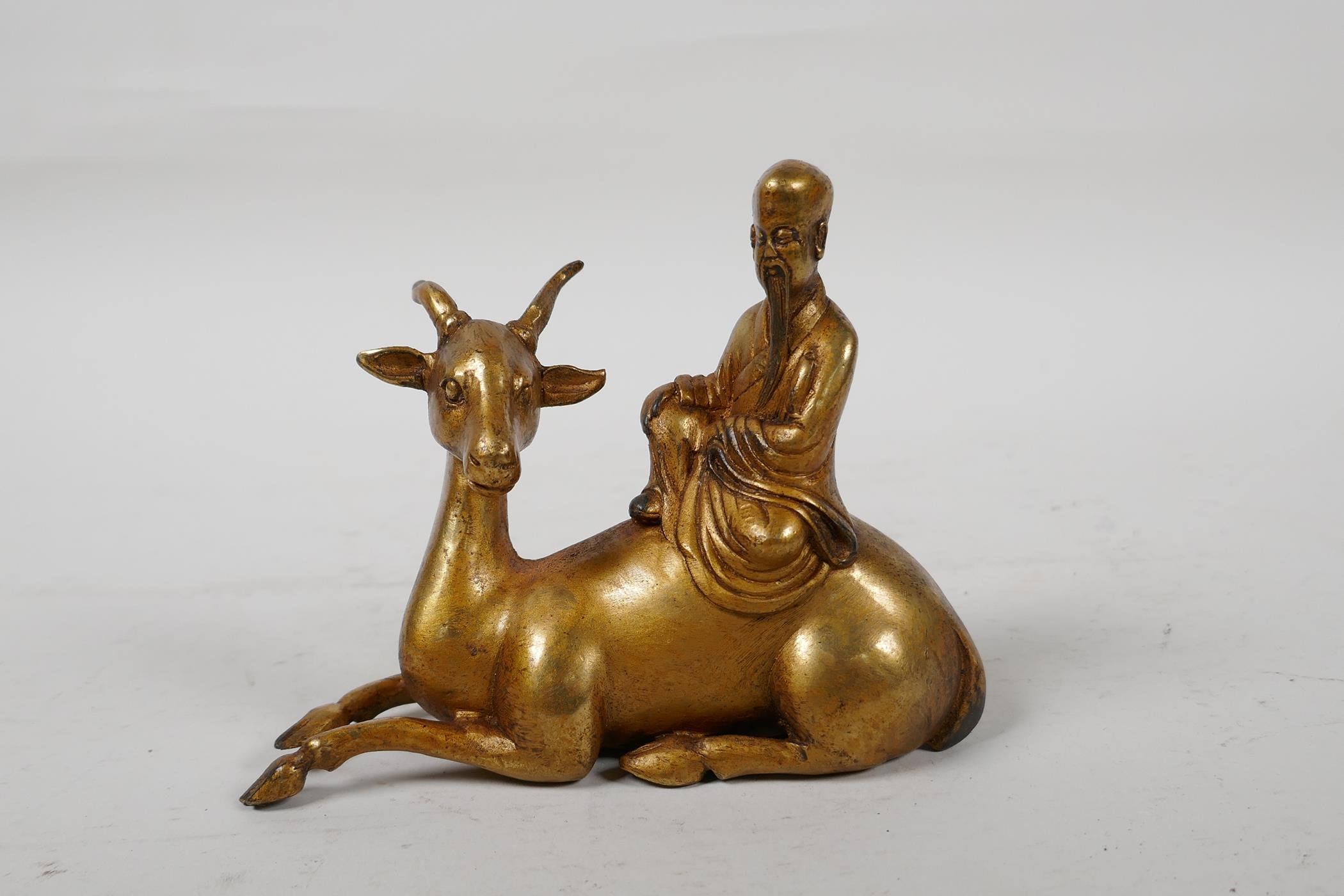 A Chinese gilt bronze of Shao Lao riding a deer, 5" long, 4" high