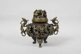 A Chinese bronzed metal censer and cover with two dragon handles and pierced dragon decoration,