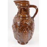 A treacle glazed earthenware jug embossed with biblical figures, 17½" high