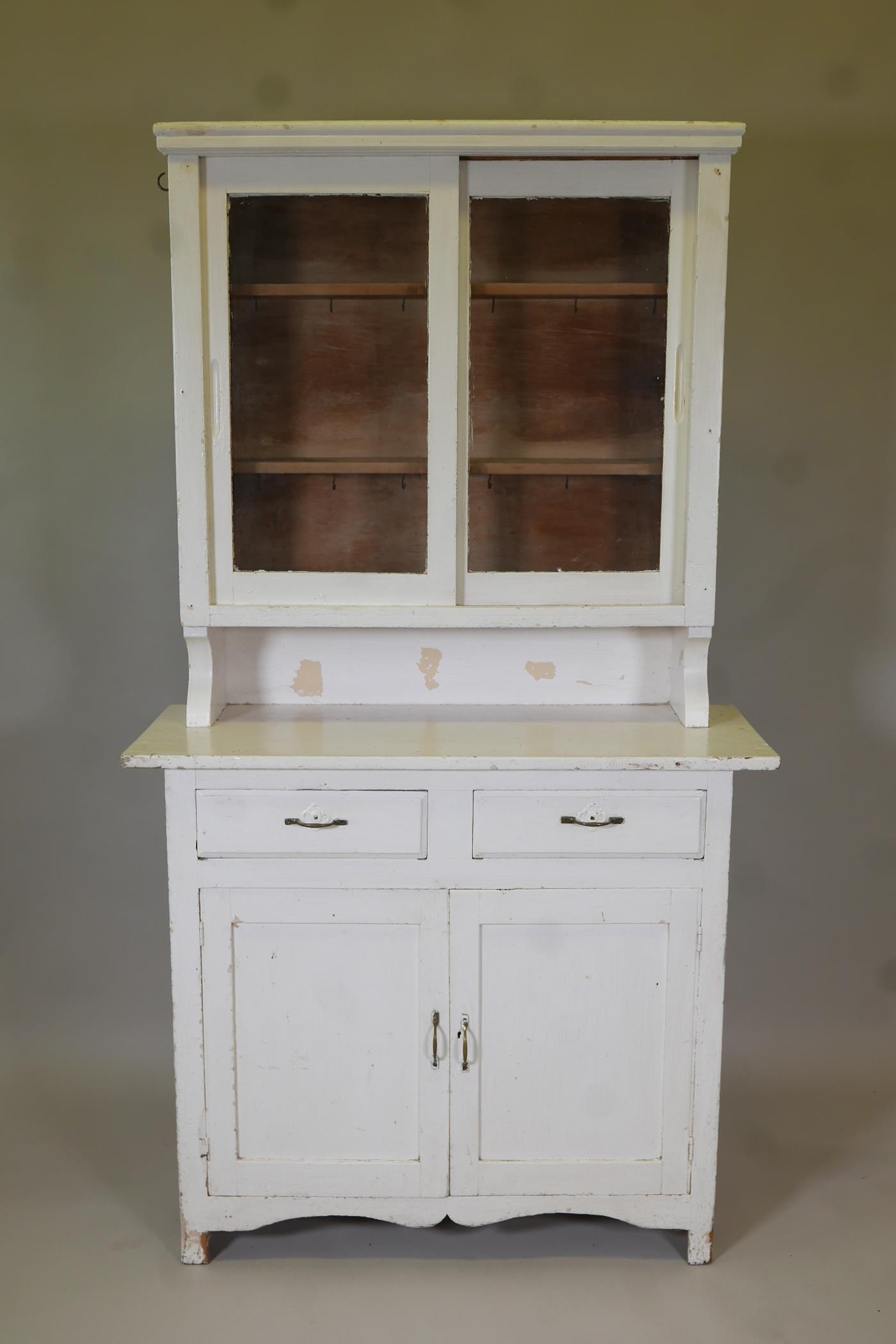 A Continental painted dresser, with glazed upper section on a base of two drawers over two