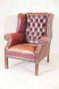 A C19th buttoned wing back armchair in red leather