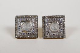 A pair of silver gilt earrings set with uncut diamonds and sapphires