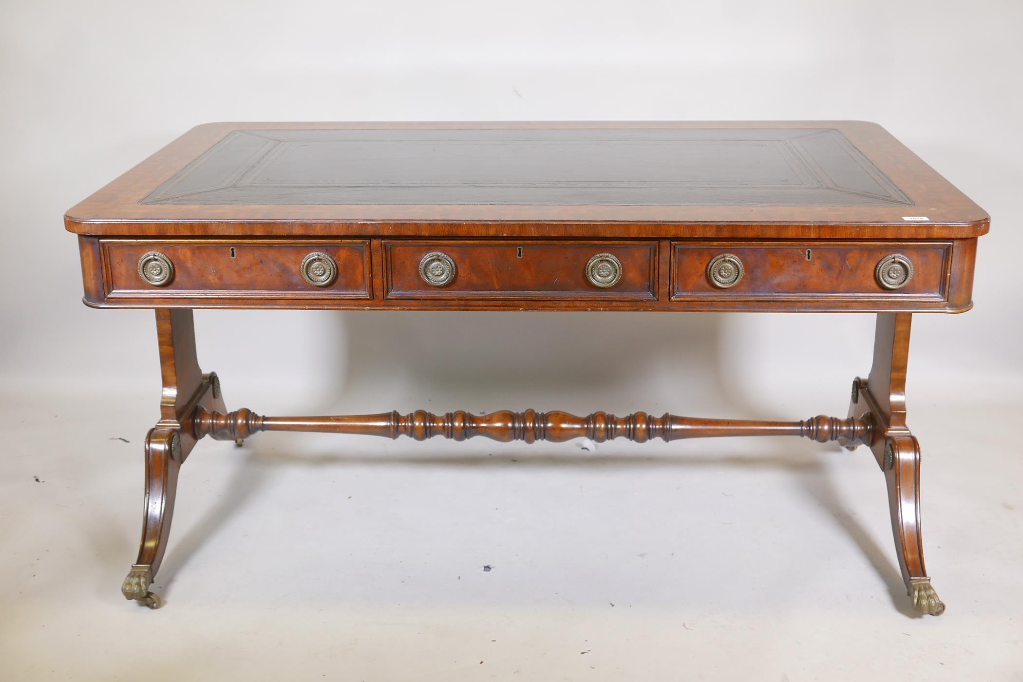 A Regency style mahogany six drawer partner's library table, with leather inset top, bears label