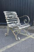 An antique painted garden chair with wrought iron scroll ends