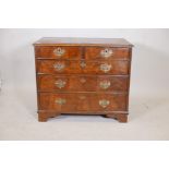 A Queen Anne walnut chest of two over three drawers, with pierced brass plate handles, raised on