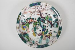 A famille vert porcelain dish decorated with women in a garden, Chinese Kangxi character mark to