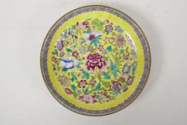 A Chinese polychrome porcelain cabinet dish with floral decoration on a yellow ground, Qianlong mark