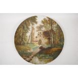 A pottery wall plaque painted with a woodland scene with building and figure, 15" diameter