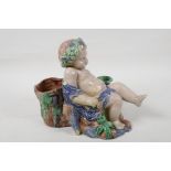 A C19th Majolica planter modelled as a Bacchanalian cherub, 8" high, restorations