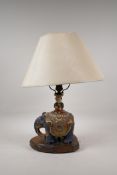 An oriental pottery lamp in the form of a child riding an elephant, 17" high