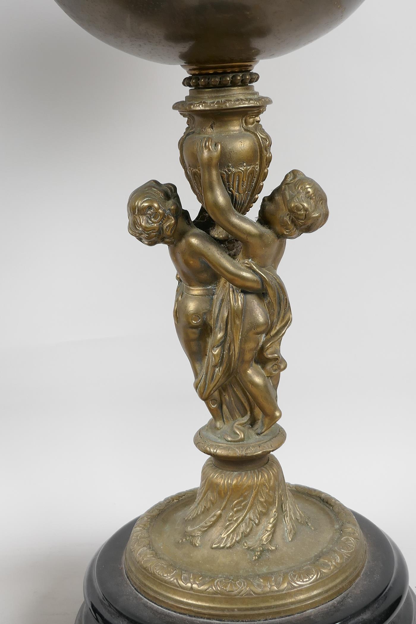 Two table lamps, the central bronze columns cast as two cherubs supporting an urn, with brass oil - Image 2 of 4