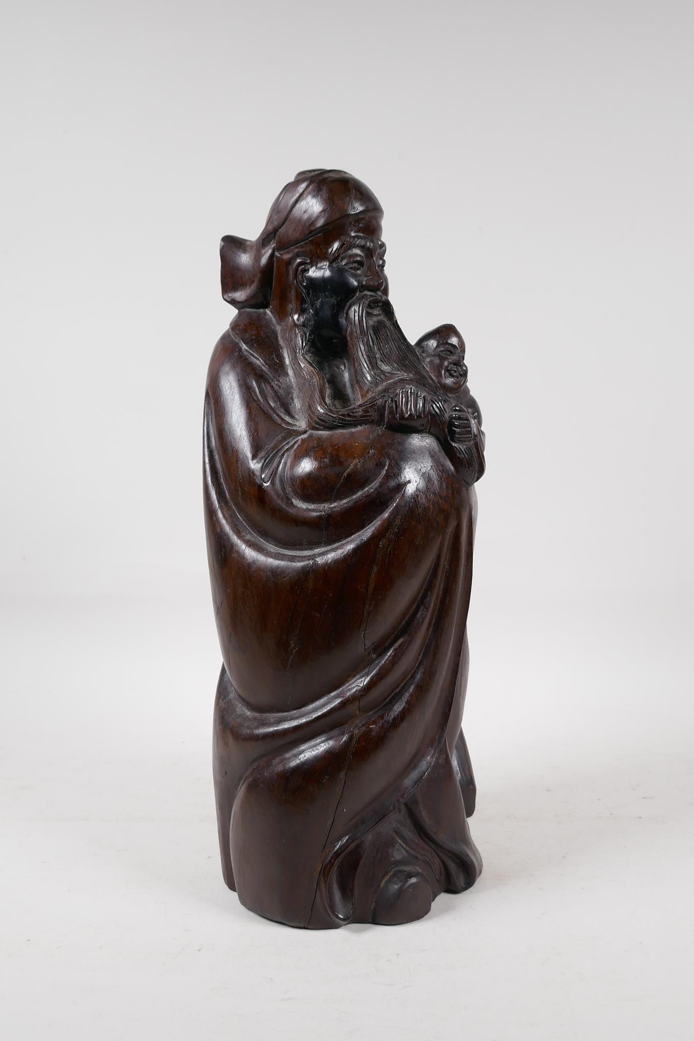 A Chinese carved hardwood figure of a sage carrying a child, 15" high - Image 2 of 5