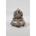 A Chinese white metal incense diffuser raised on temple lion supports, with pierced dragon