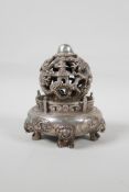 A Chinese white metal incense diffuser raised on temple lion supports, with pierced dragon