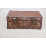 A chinoiserie lacquered pigskin trunk, with parcel gilt raised moulded decoration and brass