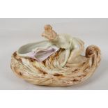 A continental porcelain bowl in the Art Nouveau style, modelled as a girl in a swirling pool, 11"