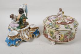 A C19th continental porcelain inkwell modelled as two children on a seesaw, 6" high, and a
