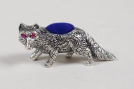 A sterling silver pincushion in the form of a fox set with ruby eyes, 1½" long