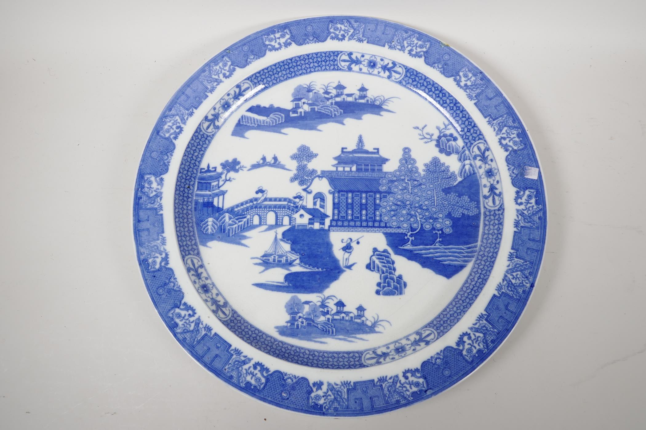 A Staffordshire blue and white charger decorated with the Long Bridge variation of the Willow